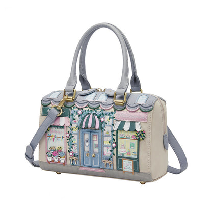 Handbag with a decorative design of buildings and shops on a white background