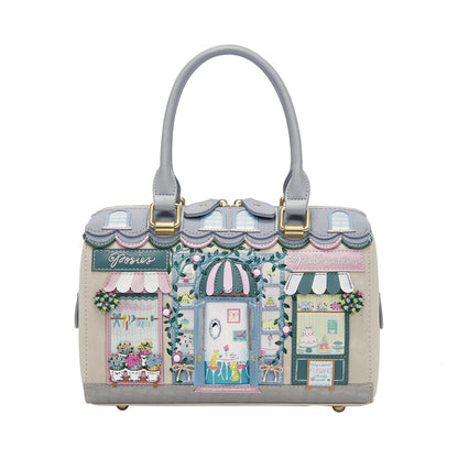 Handbag with a detailed design of a quaint town street scene on a white background