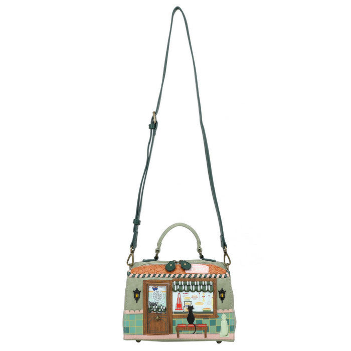 Handbag with a design of a building and cat on a white background