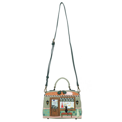 Handbag with a design of a building and cat on a white background