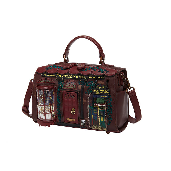 Brown leather bag with decorative elements and 'Mystic Wicks' branding on a white background