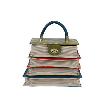 Stack of books shaped like a handbag with a visible brand emblem on a white background