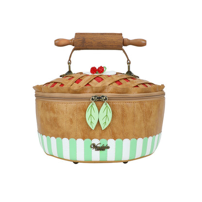Pie-shaped product with a wooden rolling pin on top, featuring a decorative design.
