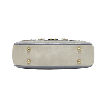 Beige handbag with gold studs on a white background