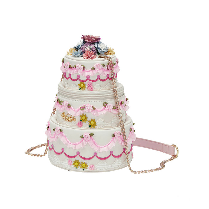 Three-tiered cake-shaped handbag with floral decorations on a white background