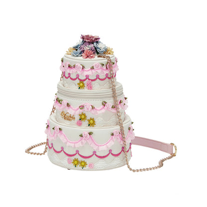 Three-tiered cake-shaped handbag with floral decorations on a white background