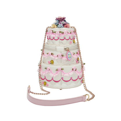 Three-tiered cake-shaped handbag with floral decorations on a white background