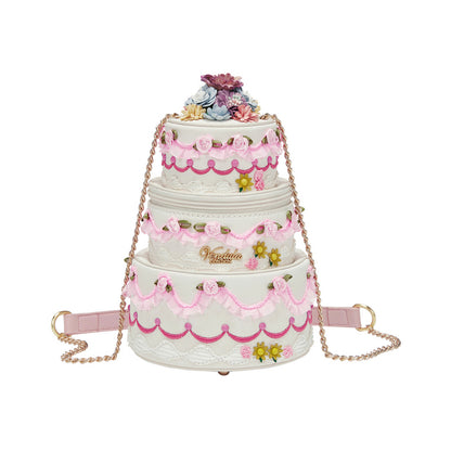 Three-tiered cake-shaped handbag with floral decorations on a white background