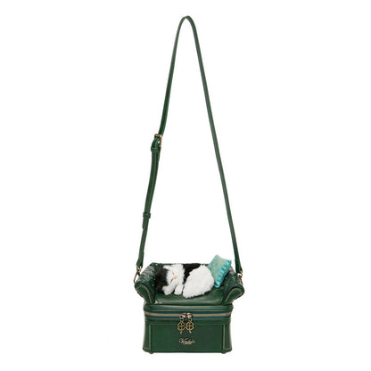 Green handbag with a small dog toy inside on a white background