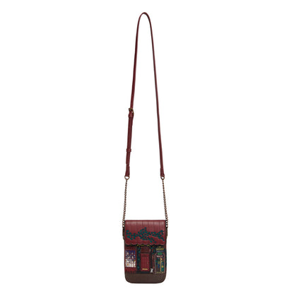 Brown handbag with a decorative strap on a white background
