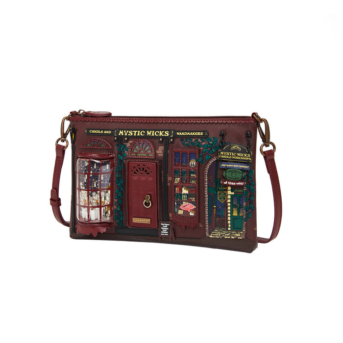 Brown leather crossbody bag with decorative panels featuring a store front design on a white background.