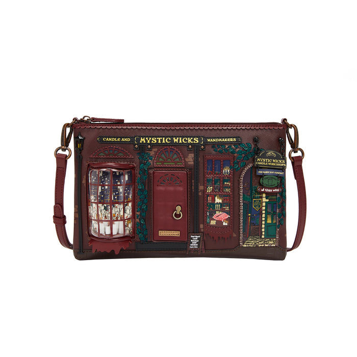 Brown leather crossbody bag with decorative elements and 'Mystic Wicks' branding on a white background