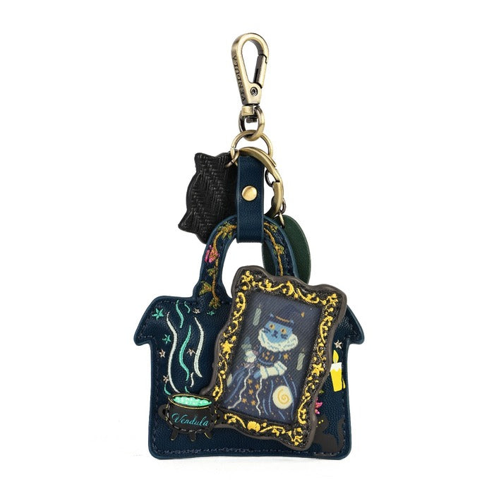 A navy blue handbag-shaped keychain featuring a whimsical moon and cat illustration, gold filigree trim, a black cat silhouette charm, and a gold carabiner clasp, shown on a plain white background.