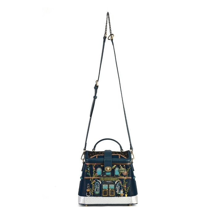 A navy blue leather handbag with an intricate multicolor embroidered pattern on the front flap, featuring a top handle, a long shoulder strap, and a silver-tone base, shown against a plain white background.