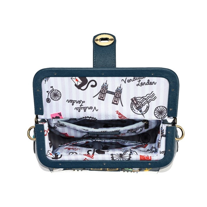 An open navy blue shoulder bag with a London-themed print lining. The exterior features a dark teal-blue fabric with gold-tone studs and a gold clasp, while the interior lining is white with black illustrations of Tower Bridge, a black cat, and the word 'London'.