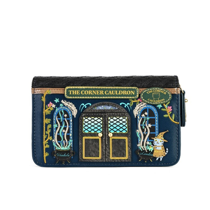 A navy blue zip-around wallet featuring an embroidered design of 'The Corner Cauldron' from Harry Potter, with gold lettering, blue and green accents, and a small wizard character on the right, shown against a plain white background.