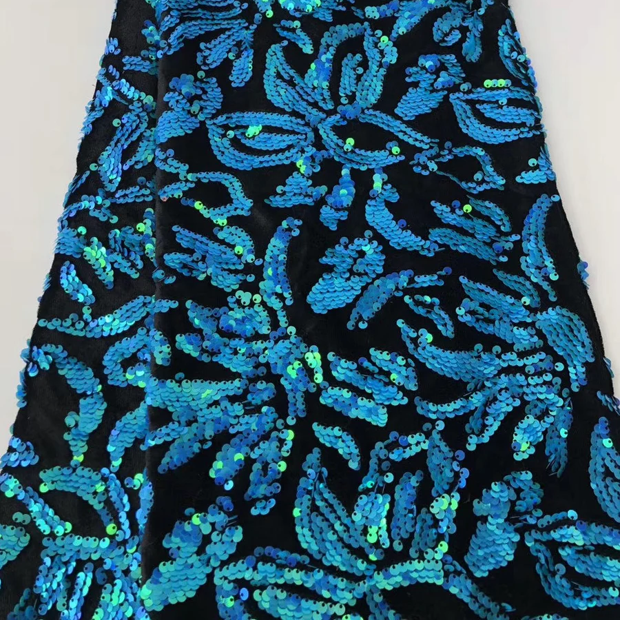 Black fabric with blue floral sequin pattern on a white background