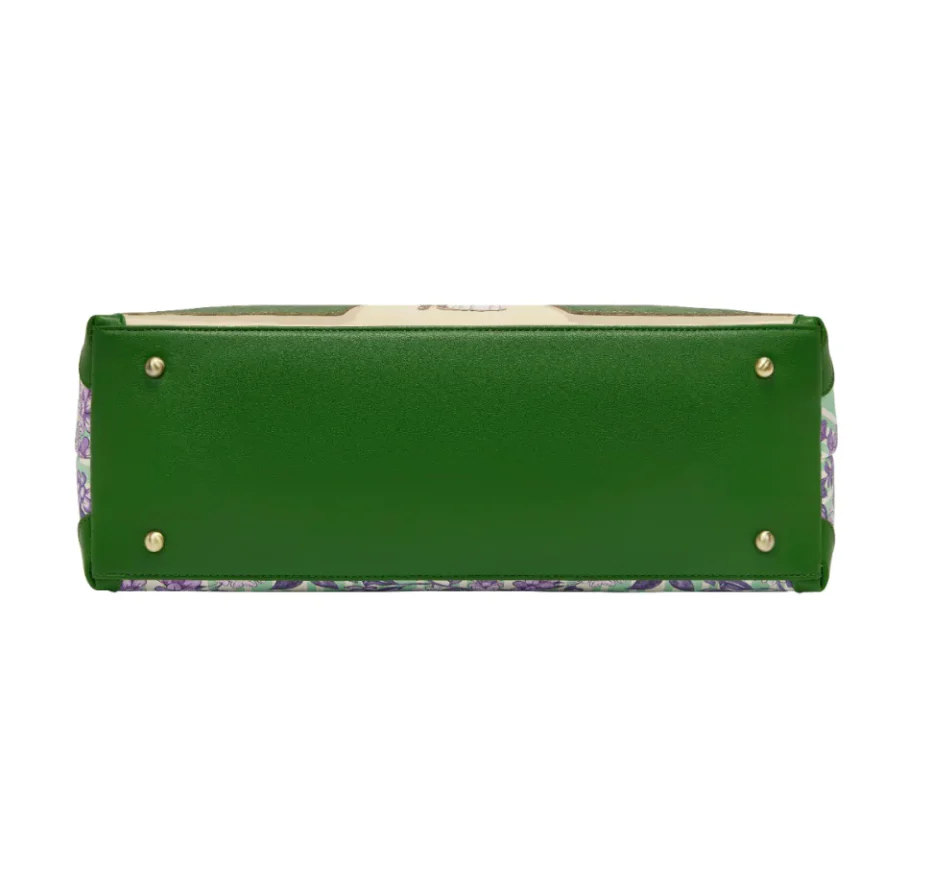 Woman holding a colorful handbag with a fairy tale design against a purple background with flowers.