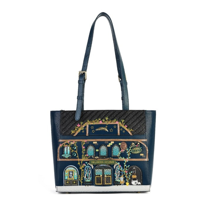 A navy blue leather tote bag featuring a highly detailed, colorful illustration of a classic London tube station facade on the front. The bag has a black textured honeycomb pattern top panel, a matching navy blue shoulder strap with gold-tone hardware, and a silver-tone metal base trim.