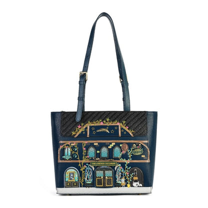 A navy blue leather tote bag featuring a highly detailed, colorful illustration of a classic London tube station facade on the front. The bag has a black textured honeycomb pattern top panel, a matching navy blue shoulder strap with gold-tone hardware, and a silver-tone metal base trim.