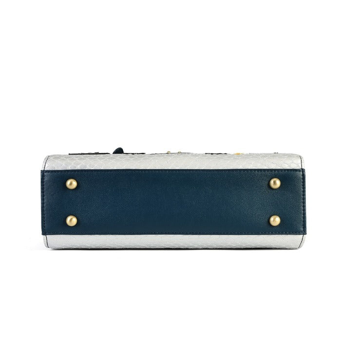 The bottom view of a rectangular clutch bag featuring a navy blue leather front panel with gold-tone metal studs, a textured light gray top and base, and a dark strap at the top.