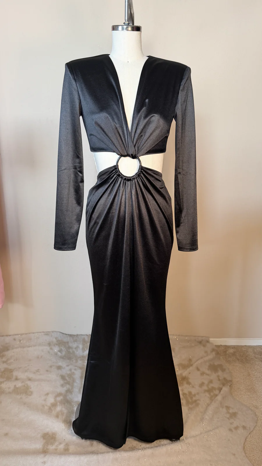 Black evening gown on a mannequin against a neutral background