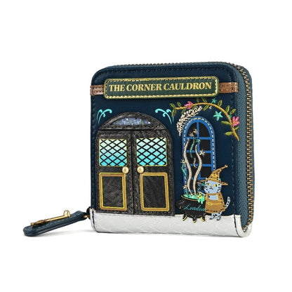 A small zip-around wallet styled as 'The Corner Cauldron' storefront, featuring dark navy blue faux leather, gold trim, embroidered details, and a silver metallic base, shown on a plain white background.