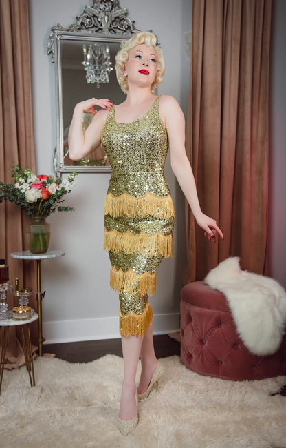 Woman in a vintage-style dress standing in a room with decorative elements.