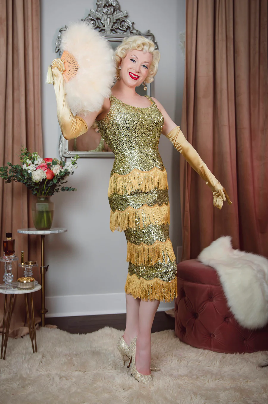 Woman in a vintage-style dress standing in a room with decorative elements.