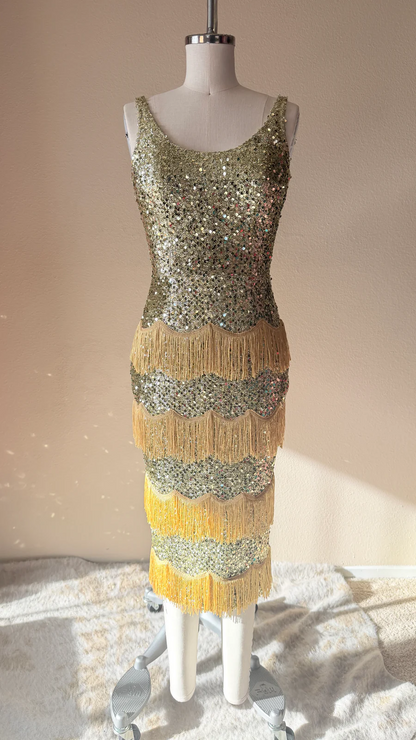 Gold sequin dress on a mannequin against a neutral background
