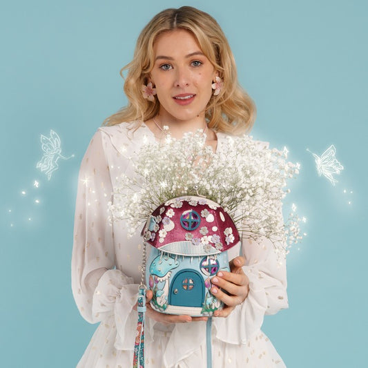 A novelty house-shaped crossbody with a secure clasp, detachable strap and compact main compartment. Printed and embossed vegan leather turns snowy toadstool houses, fairy doors, winter trees, rabbits and snowflakes into a playful winter woodland design.

