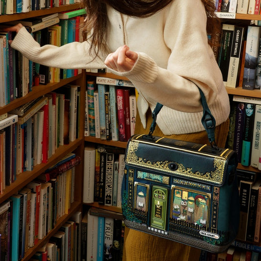 Person holding a decorative bag in a bookstore