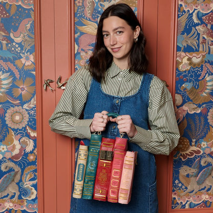 Woman holding books in front of a decorative door with floral patterns
