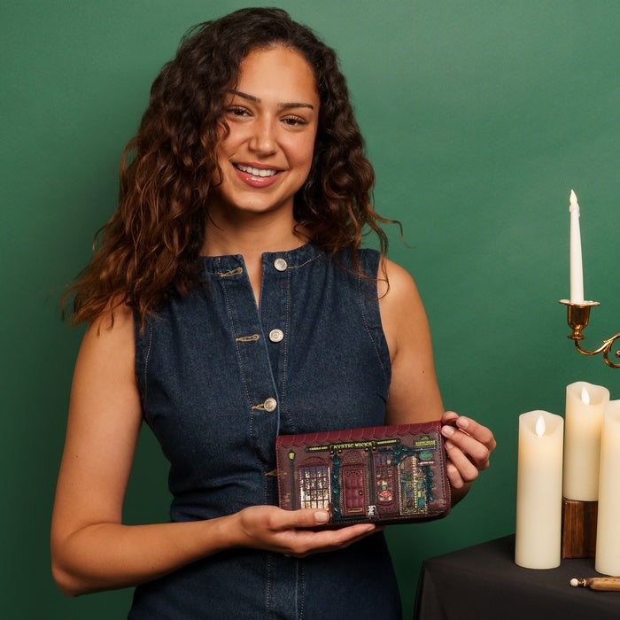 Woman holding a wallet with a vintage design against a green background