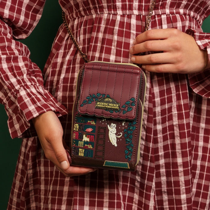 Person wearing a red and white checkered outfit holding a decorative brown bag with intricate designs.