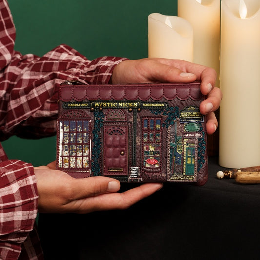 Person holding a decorative wallet with 'Mystic Micks' design against a dark background.