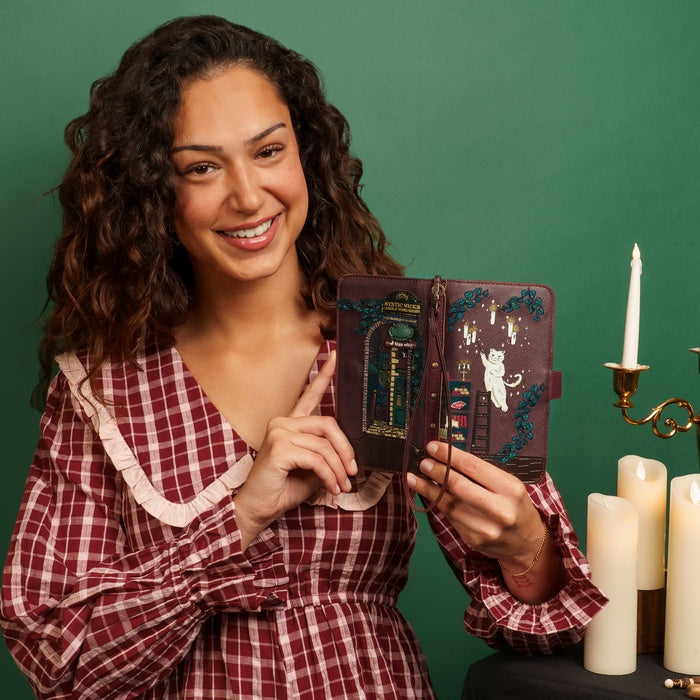 Woman holding a decorative book with candles and a candelabrum in the background
