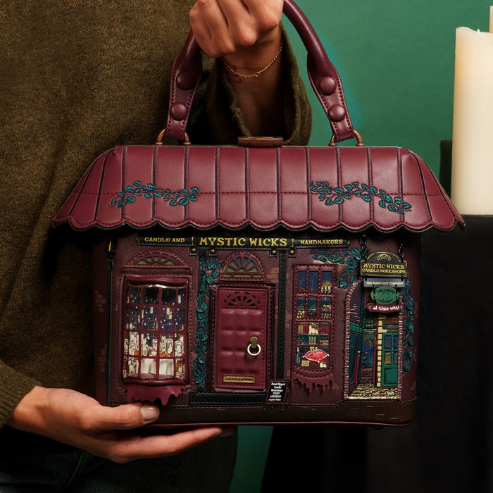 Handbag designed like a store facade with intricate details, held by a person.