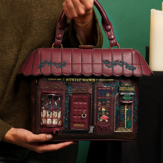 Handbag designed like a store facade with intricate details, held by a person.