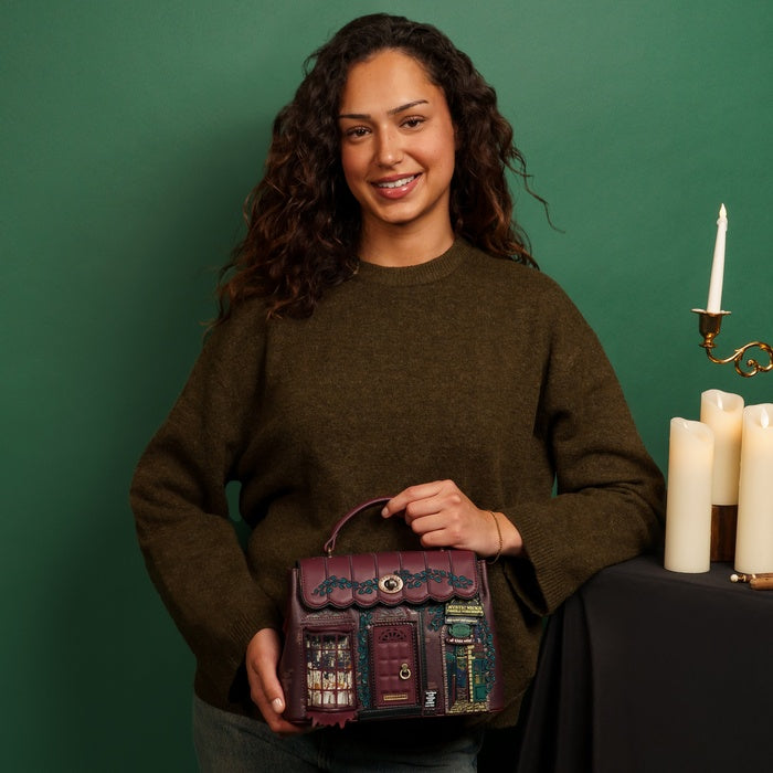 Woman holding a decorative bag with candles and a candlestick in the background