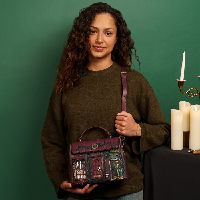Woman holding a decorative handbag with candles and a candlestick in the background