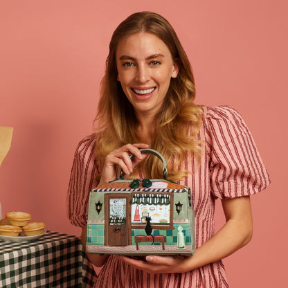 Woman holding a handbag with a vintage store design against a pink background