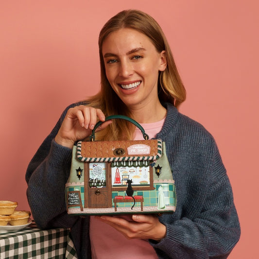 Woman holding a decorative bag with a checkered tablecloth and pastries in the background