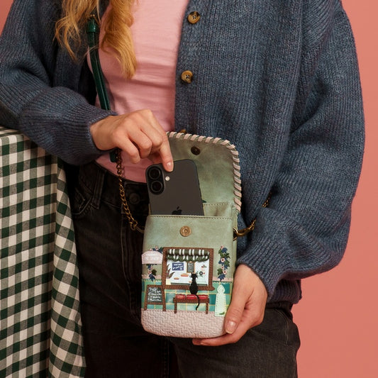 Person holding a phone case with a colorful design against a pink background