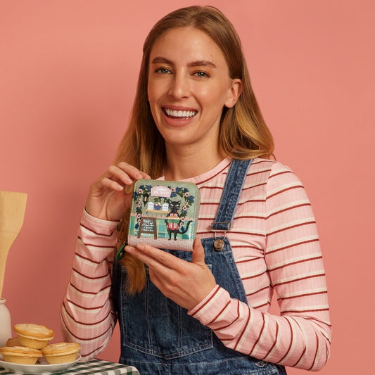 Woman holding a small square container with a pink background