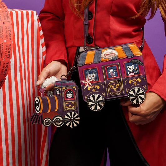 Person holding a colorful train-themed bag with another bag in the background