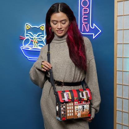 Woman holding a colorful bag in front of a neon sign with a cat design on a blue wall.