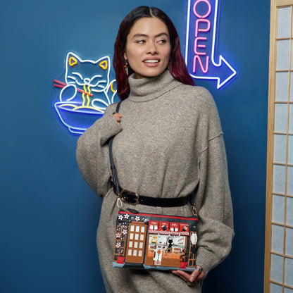 Woman holding a colorful handbag in front of a blue wall with neon signs.