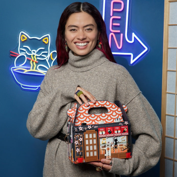 Woman holding a decorative handbag in front of a blue wall with neon signs.