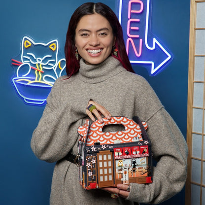 Woman holding a decorative handbag in front of a blue wall with neon signs.